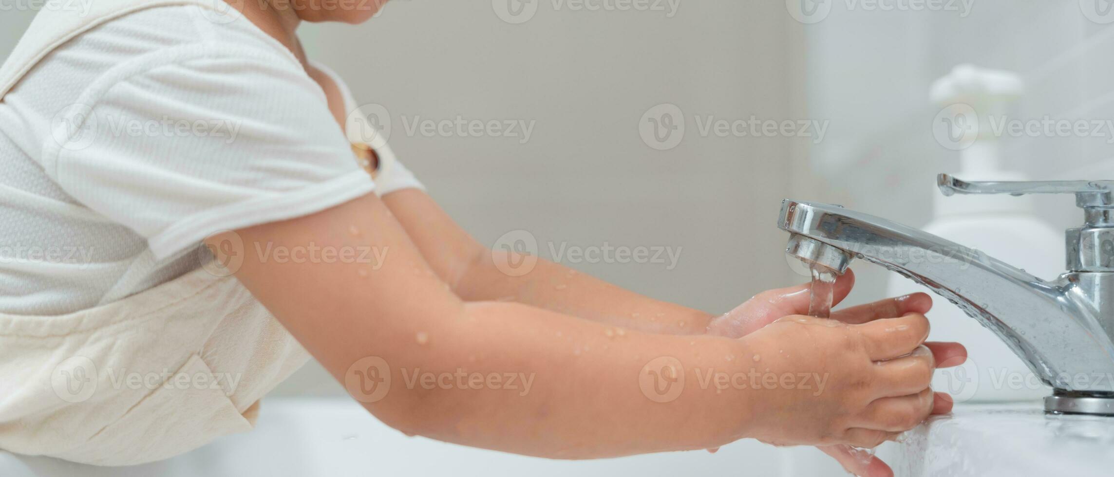 little kid hands wash with soap bubbles and rinse with clean water to prevent and stop the spread of germs after back to home, virus or covid19. Good health and good personal hygiene, virus, bacteria photo