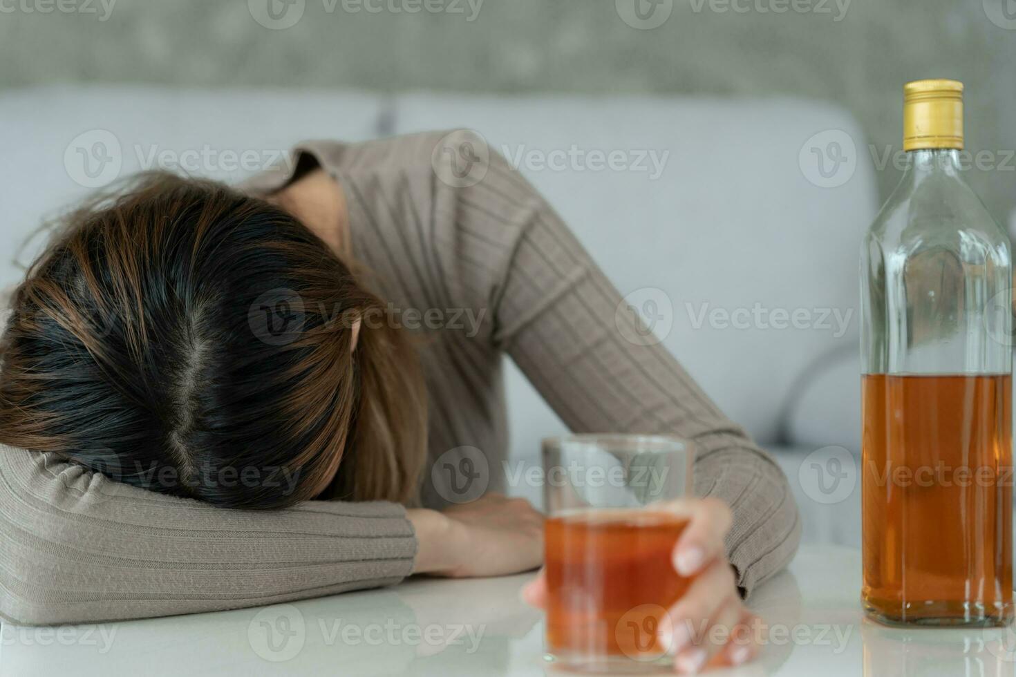 Depressed young Asian woman addicted feeling bad drinking whiskey alone at home, stressed frustrated lonely drinking alcohol suffers from problematic liquor, alcoholism, life and family problems photo