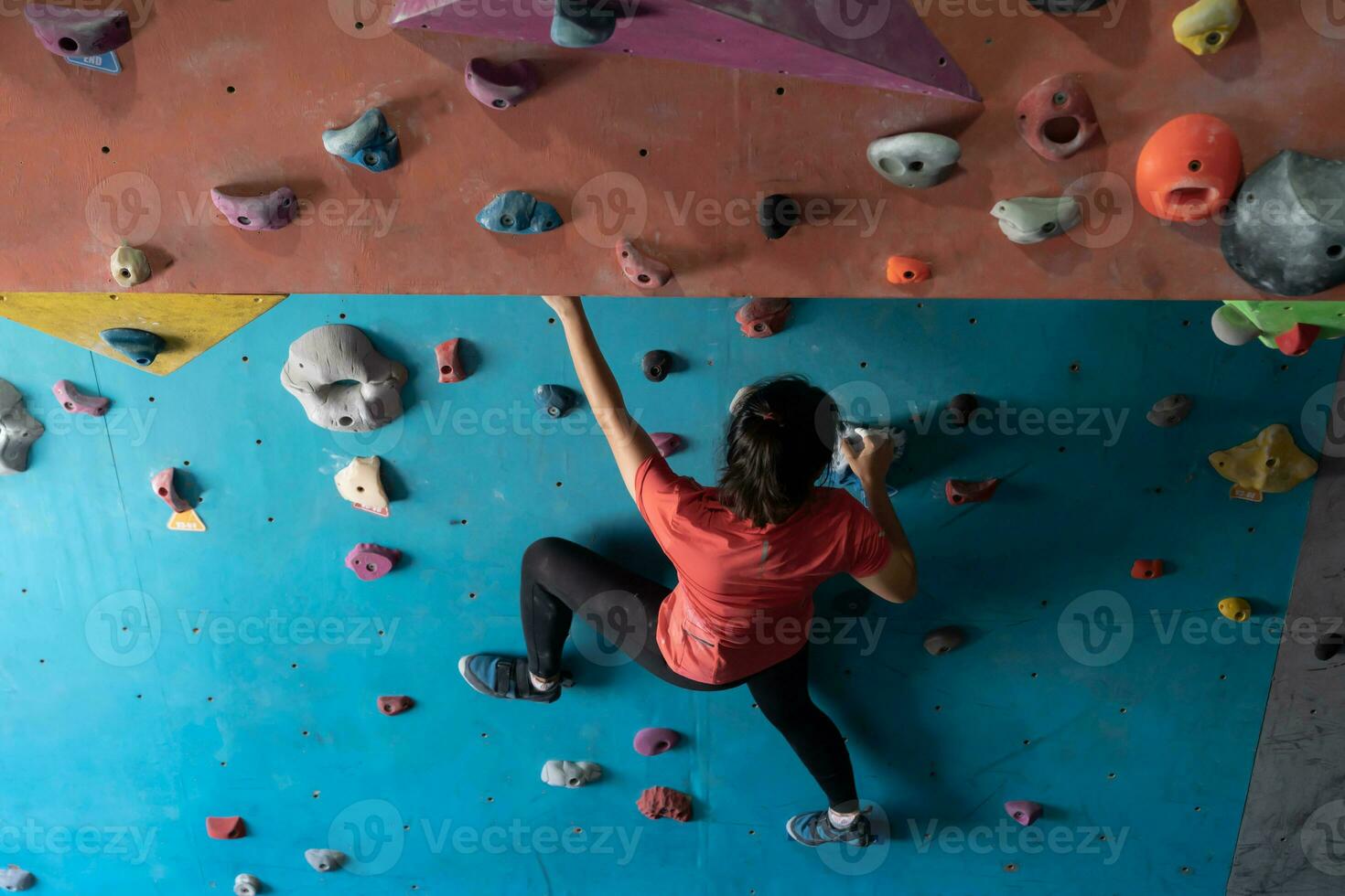 woman climbing on wall training in gym, active sporty female practicing rock climbing on artificial rock in extreme sport, bouldering, wall, climber is training, rock climbing in the city, strong photo