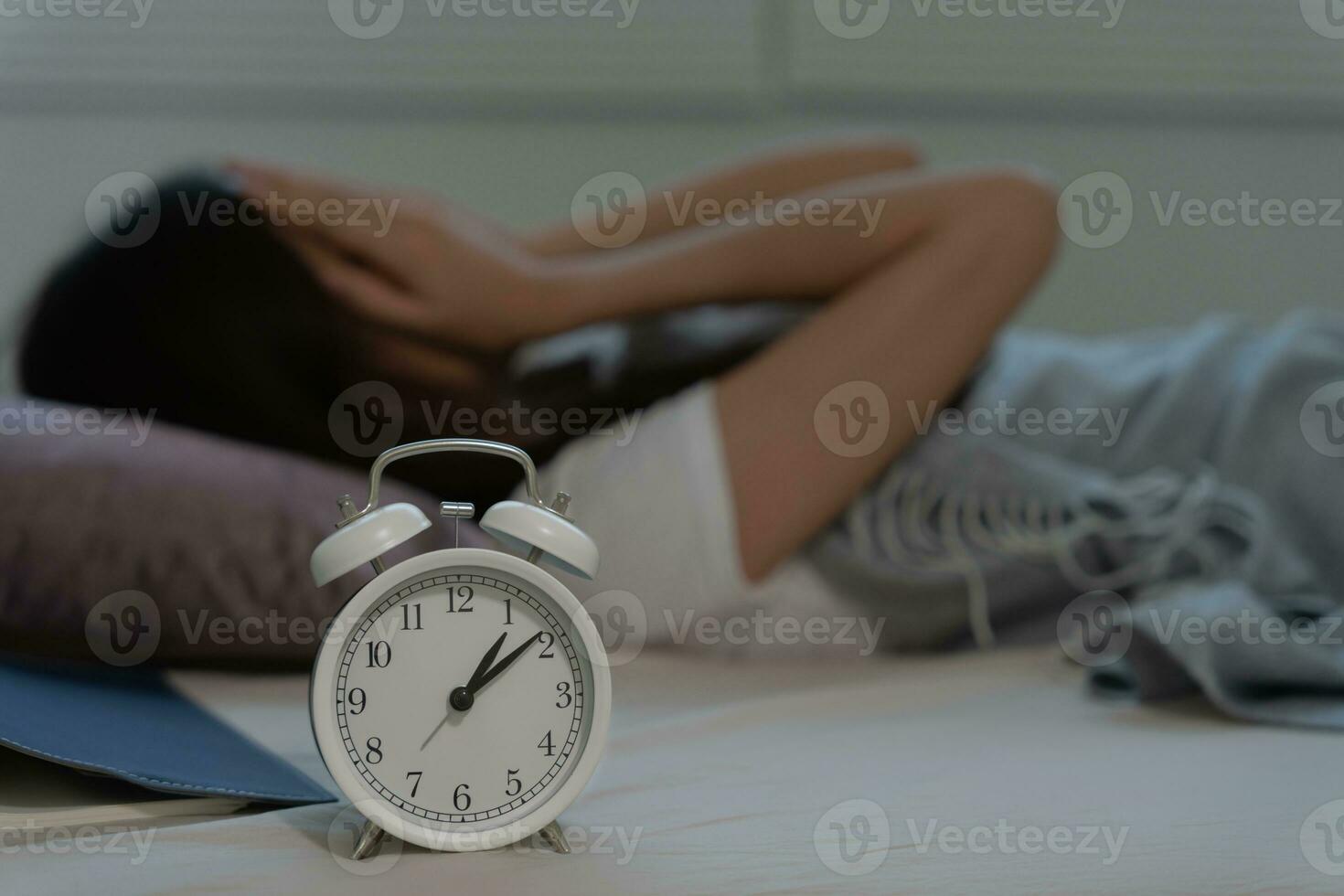 asian woman in bed late trying to sleep suffering insomnia, sleepless or scared in a nightmare, looking sad worried and stressed. Tired and headache or migraine waking up in the middle of the night. photo