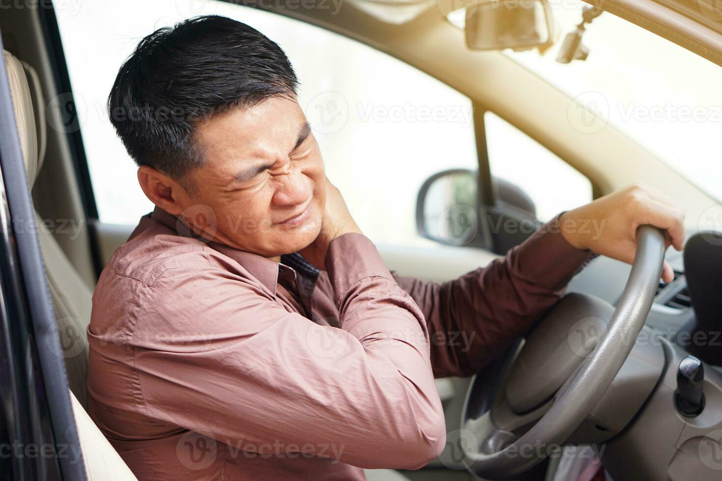 Asian man  feels hurt his neck and shoulders during his long driving in car. Concept  Injury, pain or tired from driving. Unsafe driving during abnormal symptoms. Transport, healthcare. Health problem photo