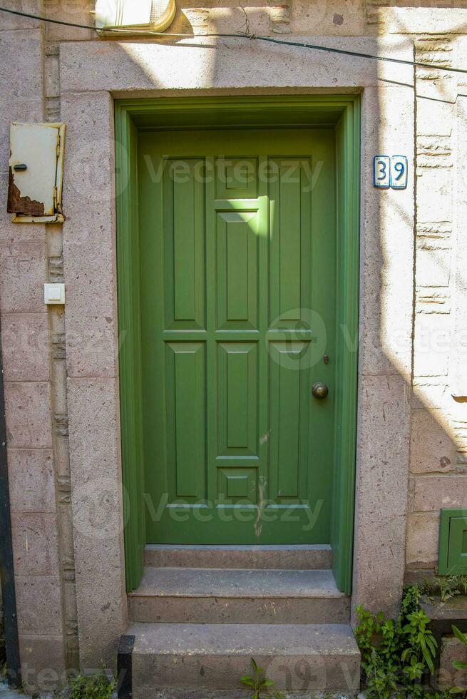 Green wooden door in the Turkish style of a stone house. photo