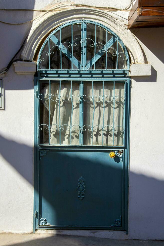 A green Turkish-style metal door with a white wall. photo