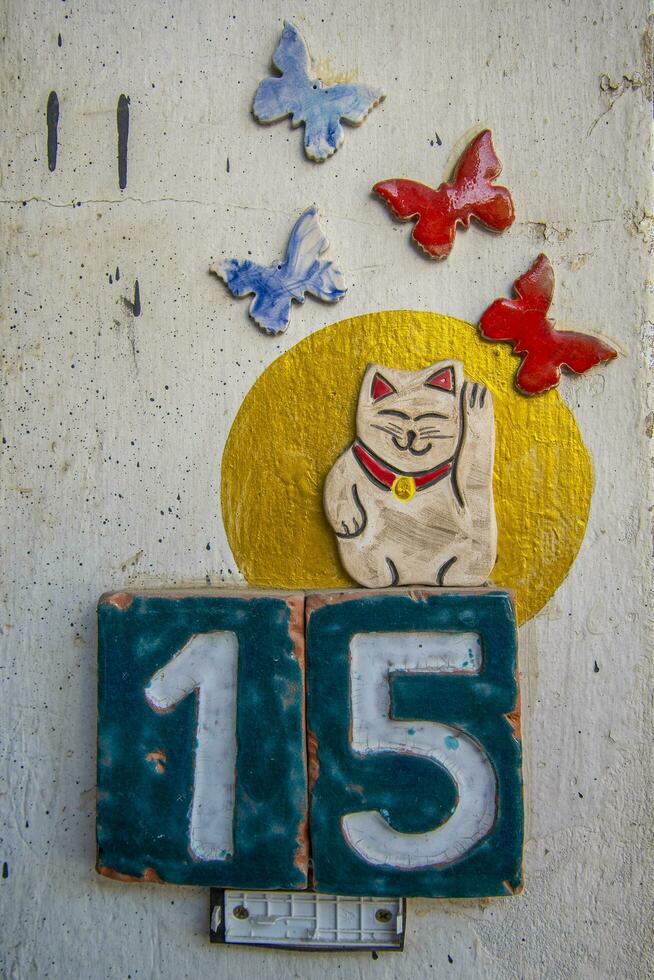 A sign with the number 15, butterflies, and a cat. photo