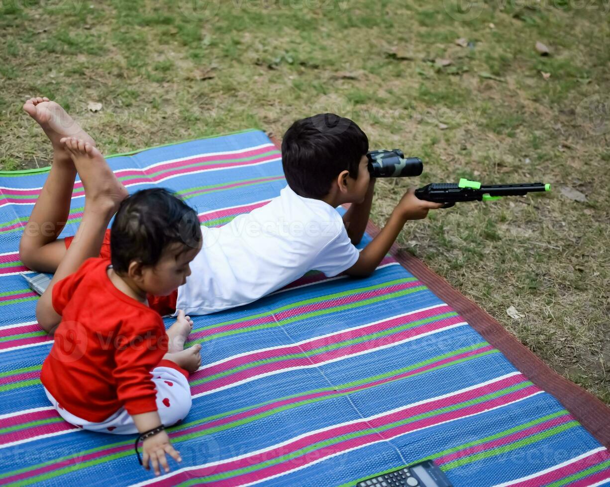 Two happy boys in society park, happy Asian brothers who are smiling happily together. Brothers play outdoors in summer, best friends. Toddler baby boy playing with his happy brother in the garden photo