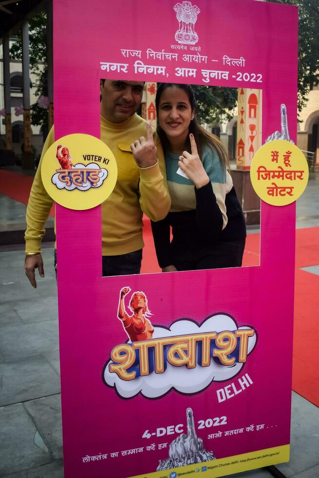 New Delhi, India - May 04 2023 - Unidentified people showing their ink-marked fingers after casting votes in front of polling booth of east Delhi area for MCD local body Elections 2022 photo