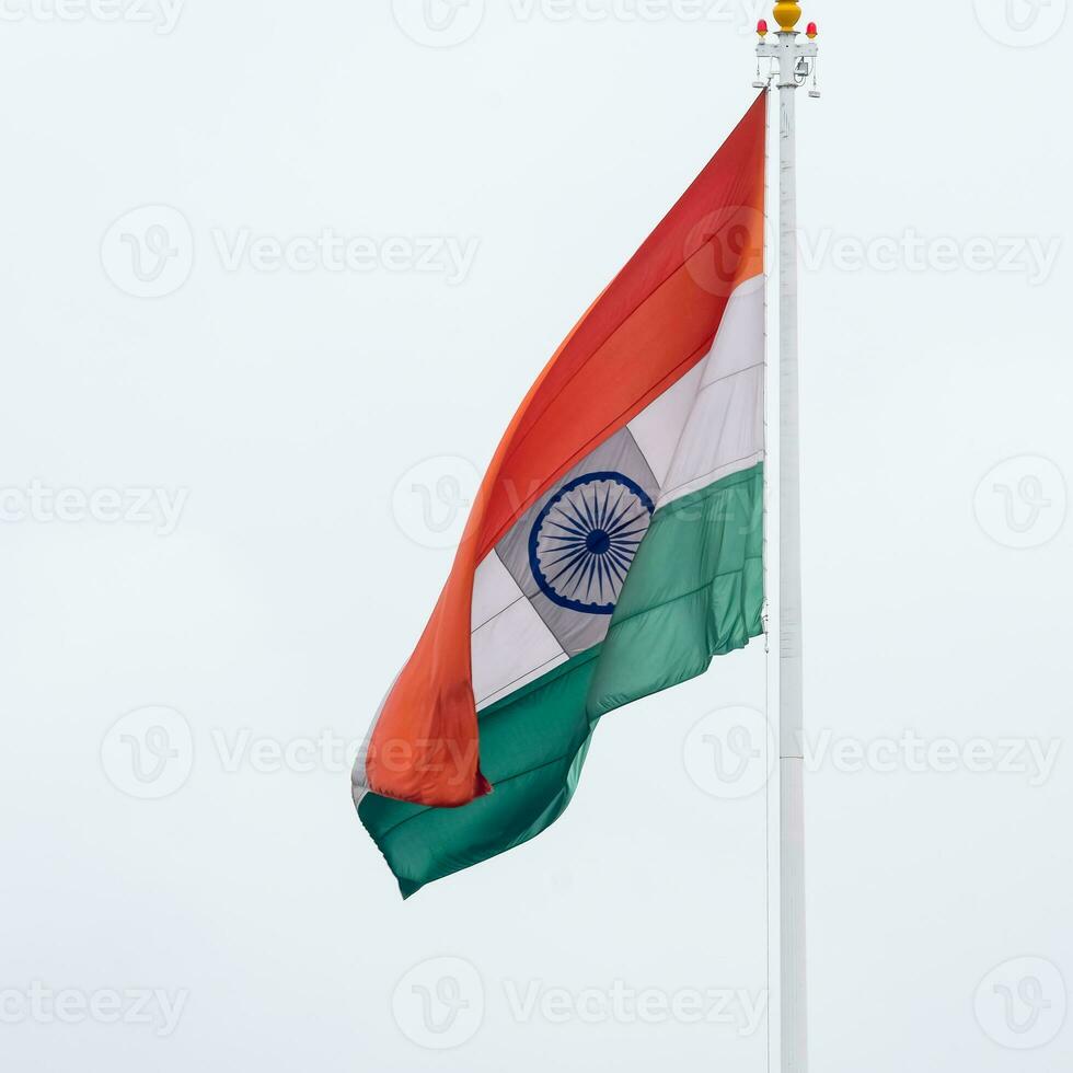 India flag flying high at Connaught Place with pride in blue sky, India flag fluttering, Indian Flag on Independence Day and Republic Day of India, tilt up shot, Waving Indian flag, Har Ghar Tiranga photo