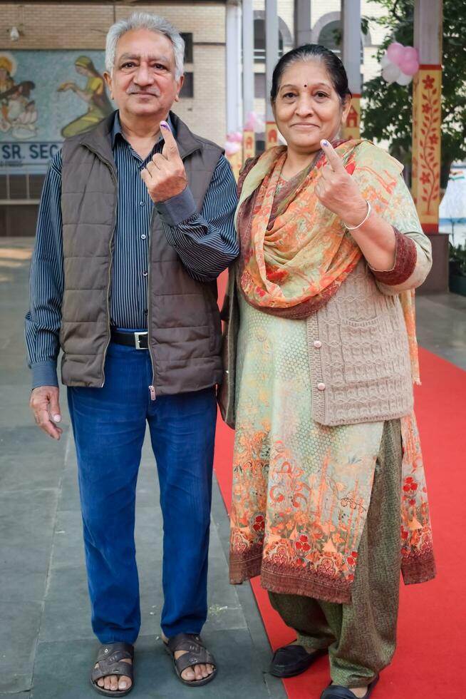 New Delhi, India - May 04 2023 - Unidentified people showing their ink-marked fingers after casting votes in front of polling booth of east Delhi area for MCD local body Elections 2022 photo