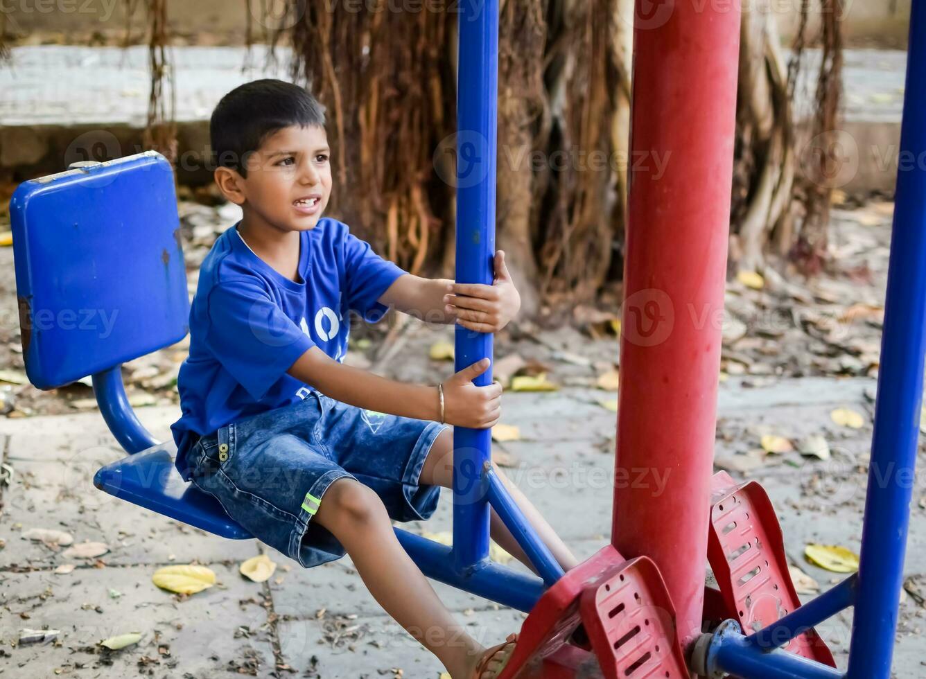 Asian boy doing routine exercise in society park during the morning time. Cute little kid exercise and gym to keep himself fit for life. Child's exercise outdoor shoot photo