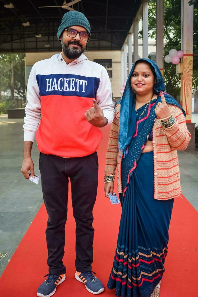 New Delhi, India - May 04 2023 - Unidentified people showing their ink-marked fingers after casting votes in front of polling booth of east Delhi area for MCD local body Elections 2022 photo