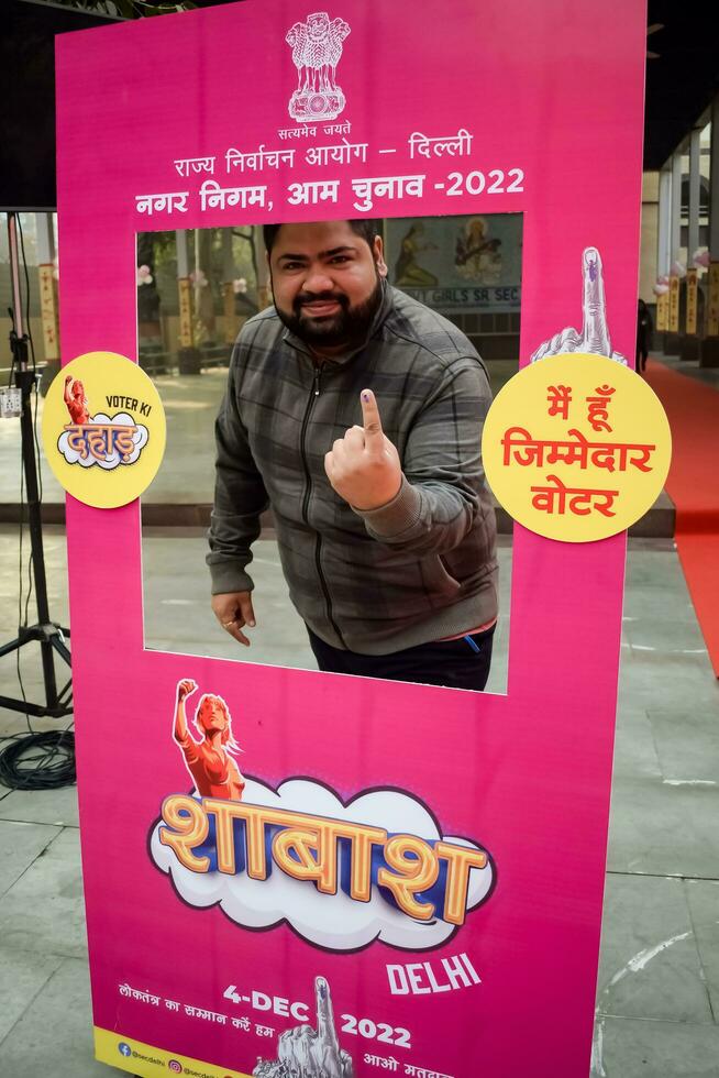 New Delhi, India - May 04 2023 - Unidentified people showing their ink-marked fingers after casting votes in front of polling booth of east Delhi area for MCD local body Elections 2022 photo