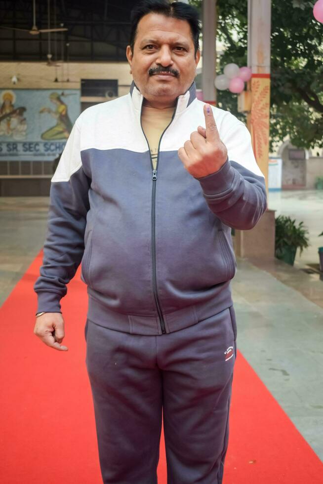 New Delhi, India - May 04 2023 - Unidentified people showing their ink-marked fingers after casting votes in front of polling booth of east Delhi area for MCD local body Elections 2022 photo