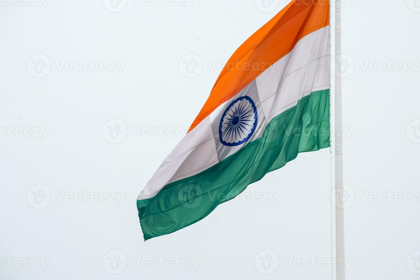 India flag flying high at Connaught Place with pride in blue sky, India flag fluttering, Indian Flag on Independence Day and Republic Day of India, tilt up shot, Waving Indian flag, Har Ghar Tiranga photo