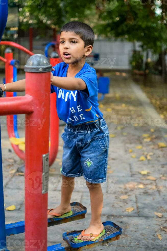 asiático chico haciendo rutina ejercicio en sociedad parque durante el Mañana tiempo. linda pequeño niño ejercicio y gimnasio a mantener él mismo ajuste para vida. niño ejercicio al aire libre disparar foto