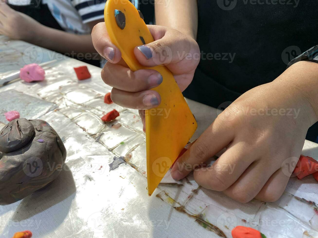 close up hands child cutting clay for sculpture. photo