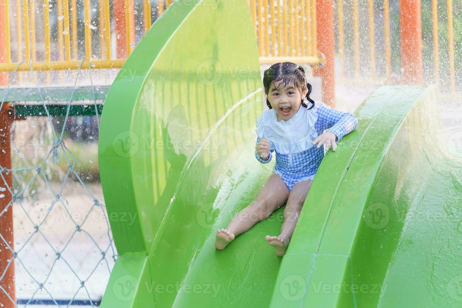 asiático linda bebé niña hija riendo contento y nadando jugando diapositiva piscina en el piscina a el complejo, sonriente y reír. teniendo divertido en el piscina a el recurso hotel, familia contento concepto. foto