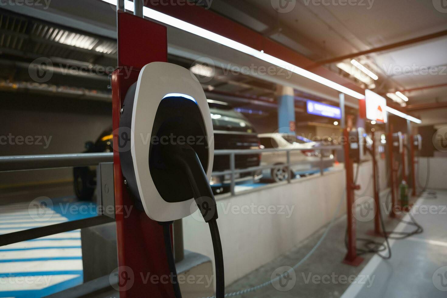 EV Car charging station for charge EV battery. Plug for vehicle with electric engine. EV charger. Clean energy. Charging point at car parking lot. Future transport technology modern car concept. photo