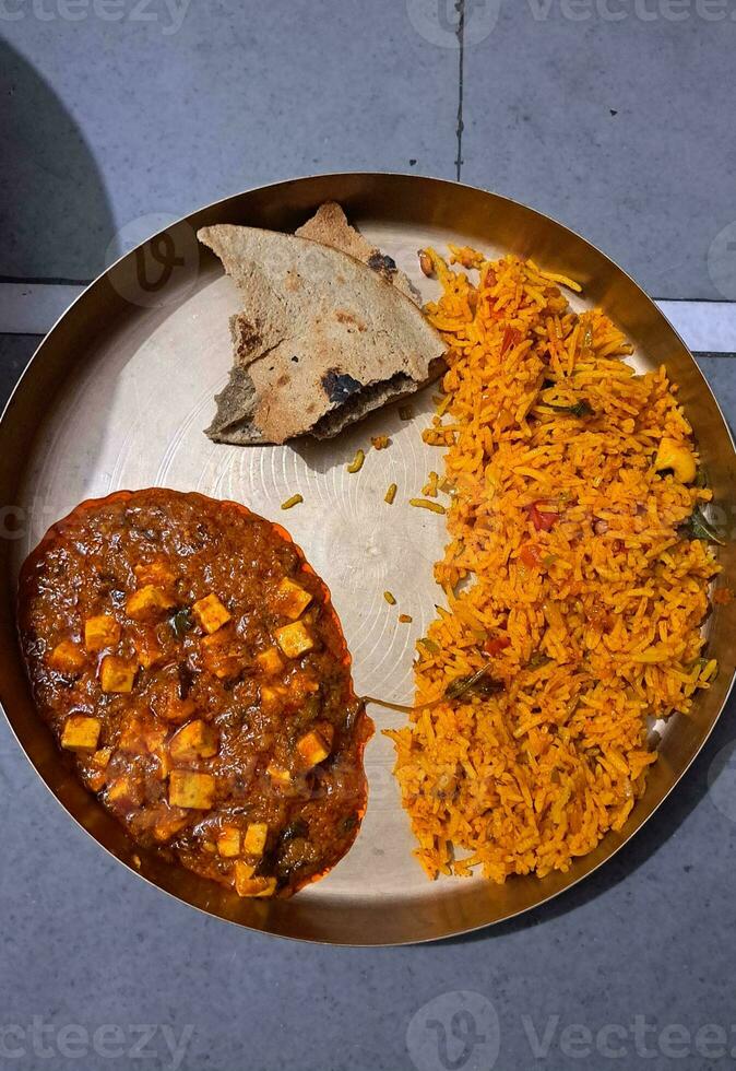 A golden Indian food dish with Cheese, Pilaf, fry rice, and pearl millet bread. photo