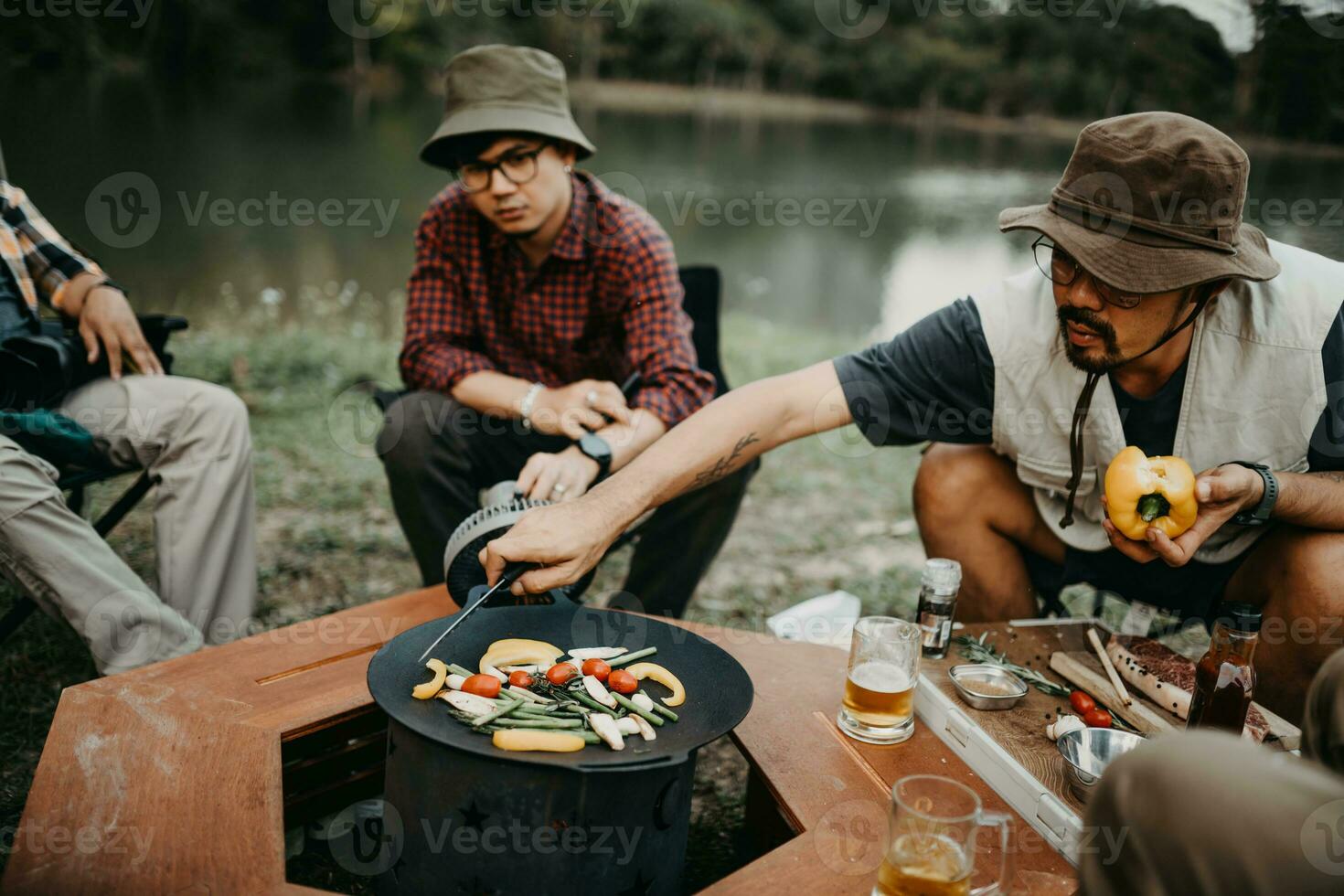 Young man cooking steak on a camping trip photo