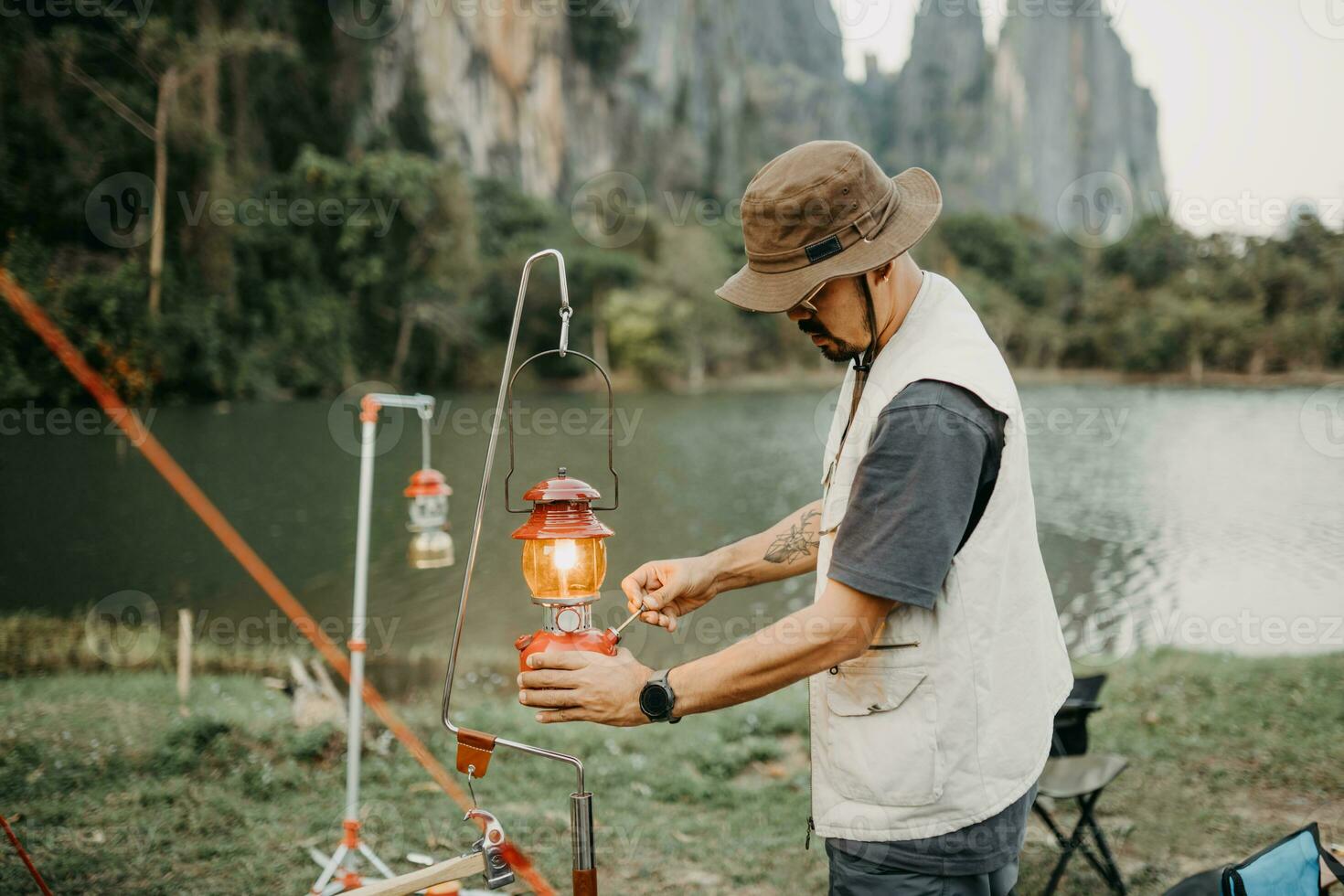 joven camper Encendiendo un linterna el solo cámping en Laos foto