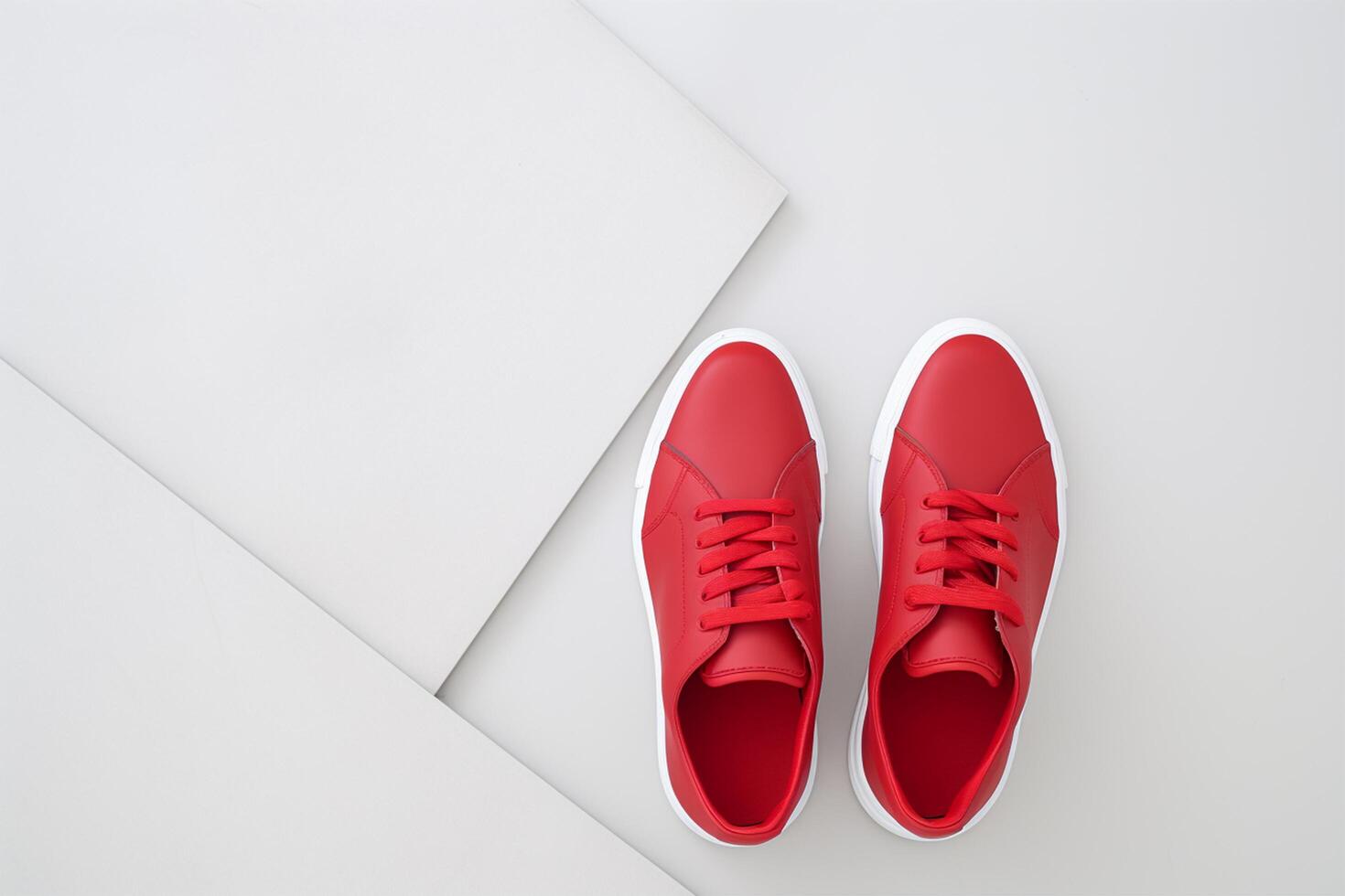 Pair of new stylish white sneakers on red background. International Red Sneakers Day. photo