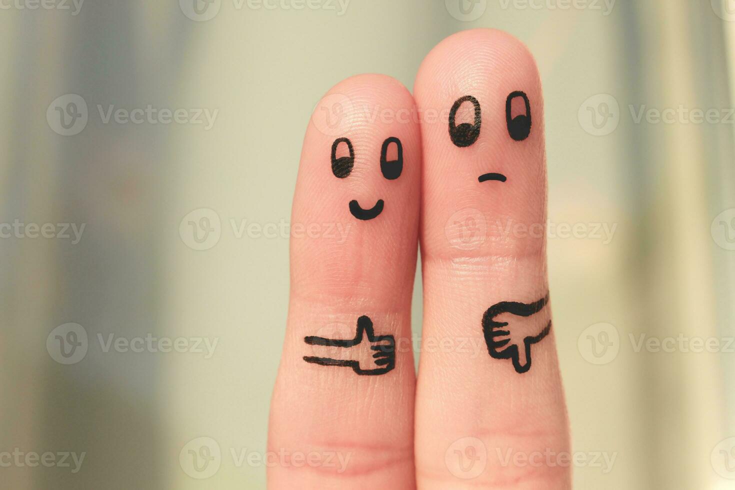 Finger art of couple. Woman showing thumbs up and man showing thumbs down. Concept of disagreement in family. photo