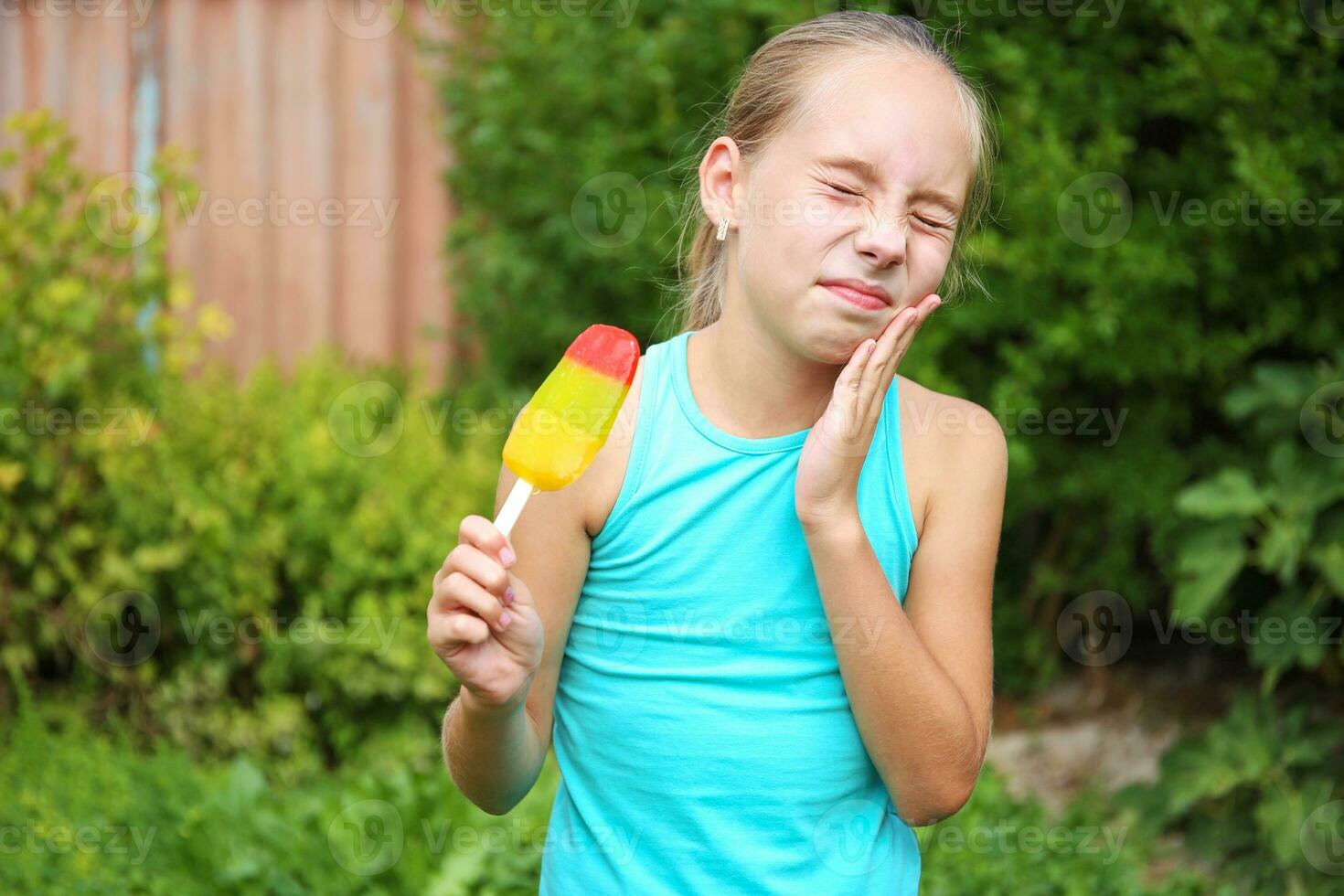 Girl has toothache from cold ice cream. photo