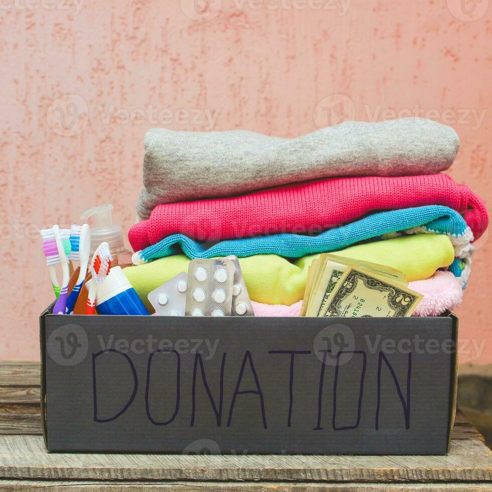 Donation box with clothes, living essentials and money. Toned image. photo