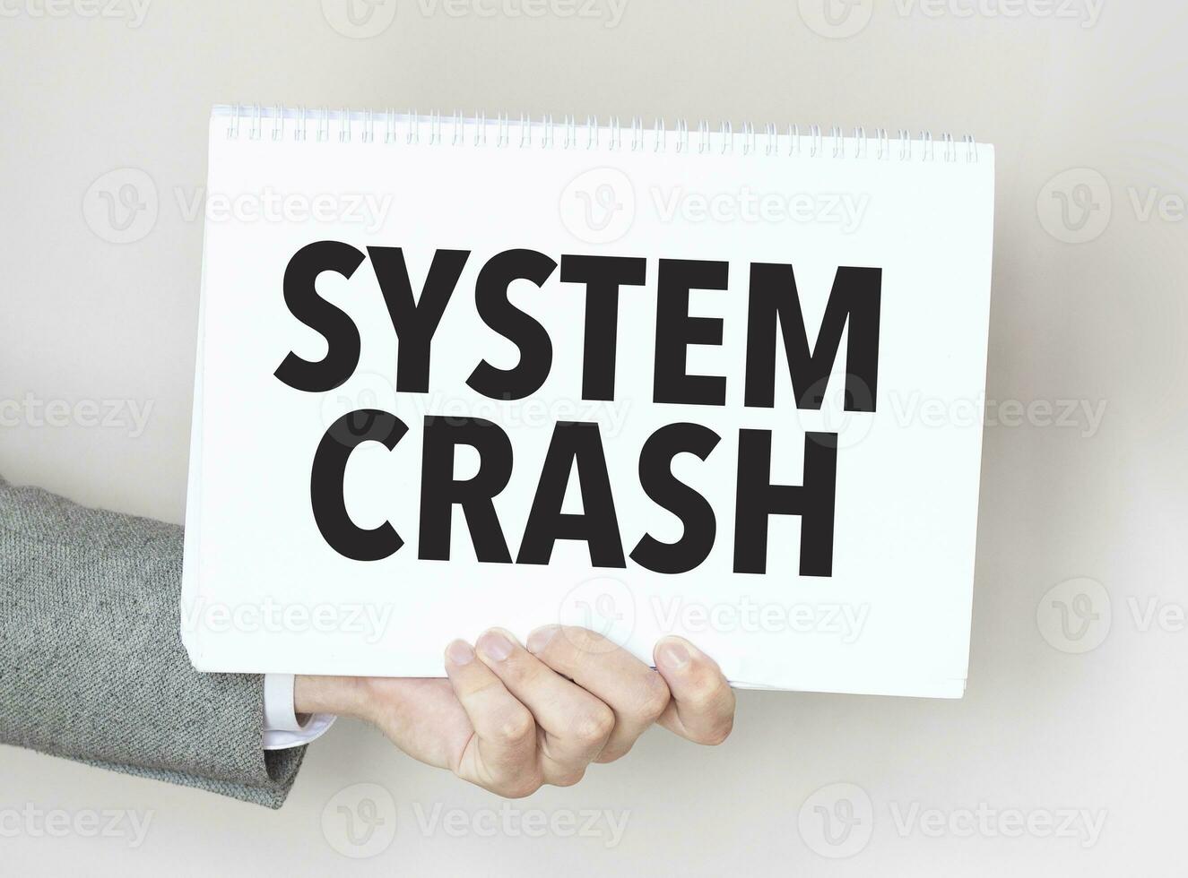 Businessman holding a card with text SYSTEM CRASH photo
