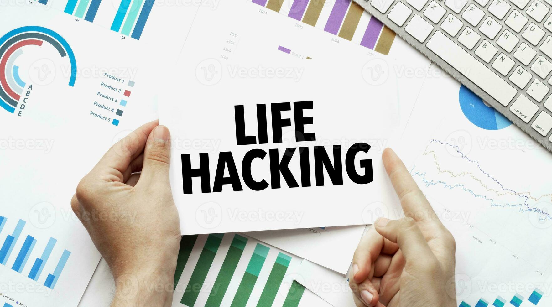 Businessman holding a card with text LIFE HACKING .Keyboard, diagram and white background photo