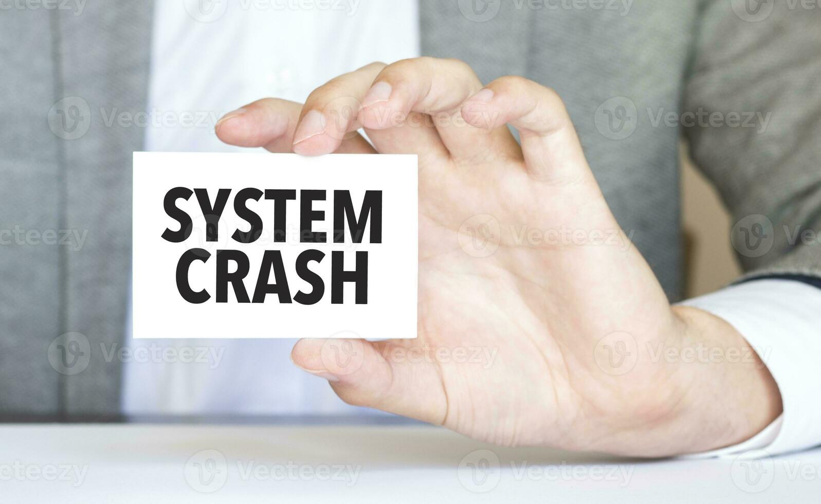 Businessman holding a card with text SYSTEM CRASH photo