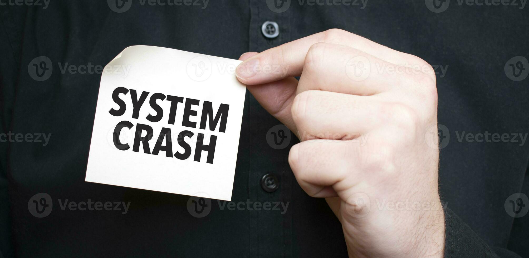 Businessman holding a card with text SYSTEM CRASH , business concept photo