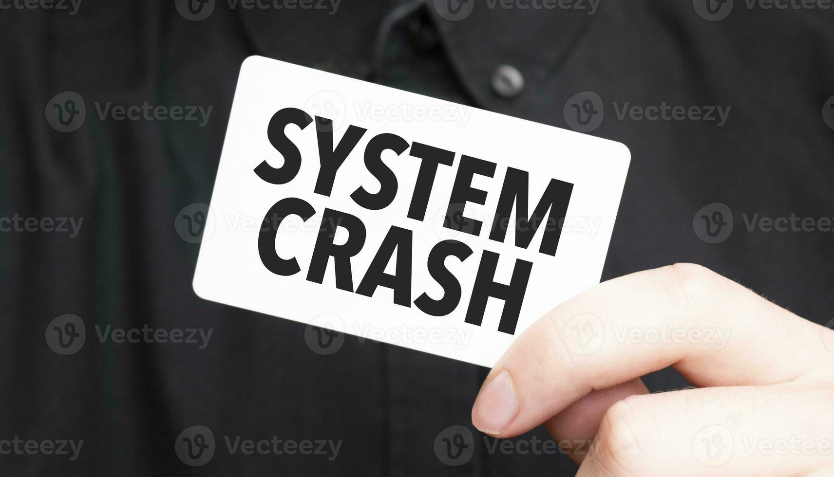 Businessman holding a card with text SYSTEM CRASH, business concept photo
