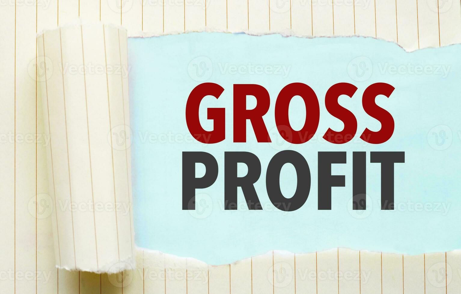 Text GROSS PROFIT appearing behind torn white paper photo