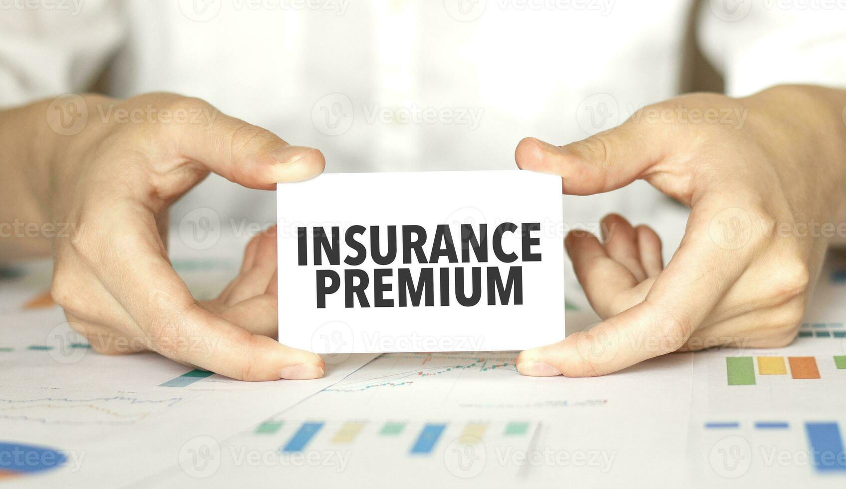 Businesswoman holding a card with text insurance premium photo