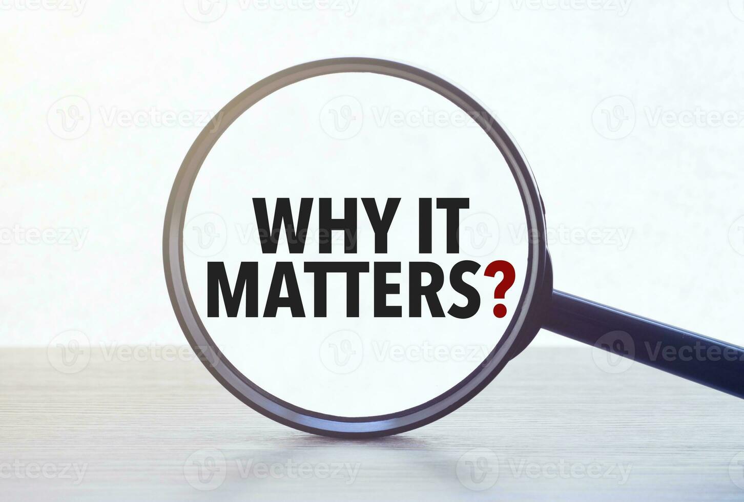 Magnifying glass with text why it matters on wooden table. photo