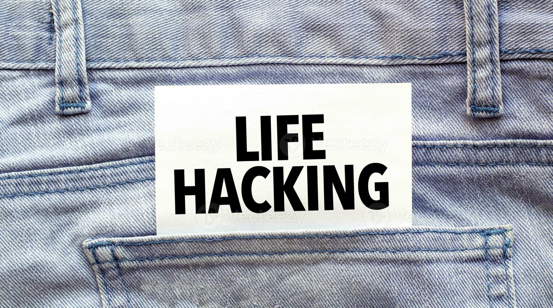 Text LIFE HACKING on a white paper stuck out from jeans pocket. Business concept photo