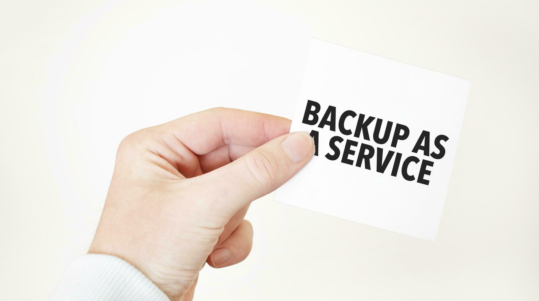 Businessman holding a card with text BACKUP AS A SERVICE business concept photo