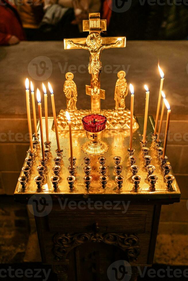 candles burn on funeral memorial table in church photo