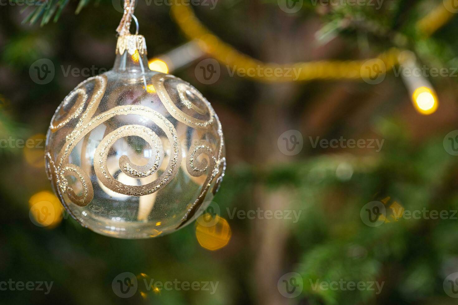 ball with golden pattern on christmas tree closeup photo