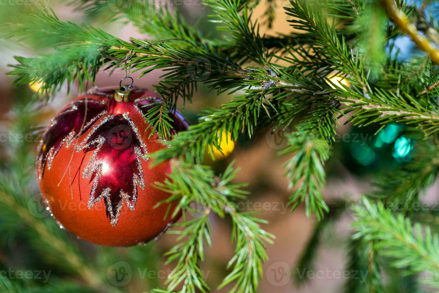 red glass ball with leaf pattern on christmas tree photo