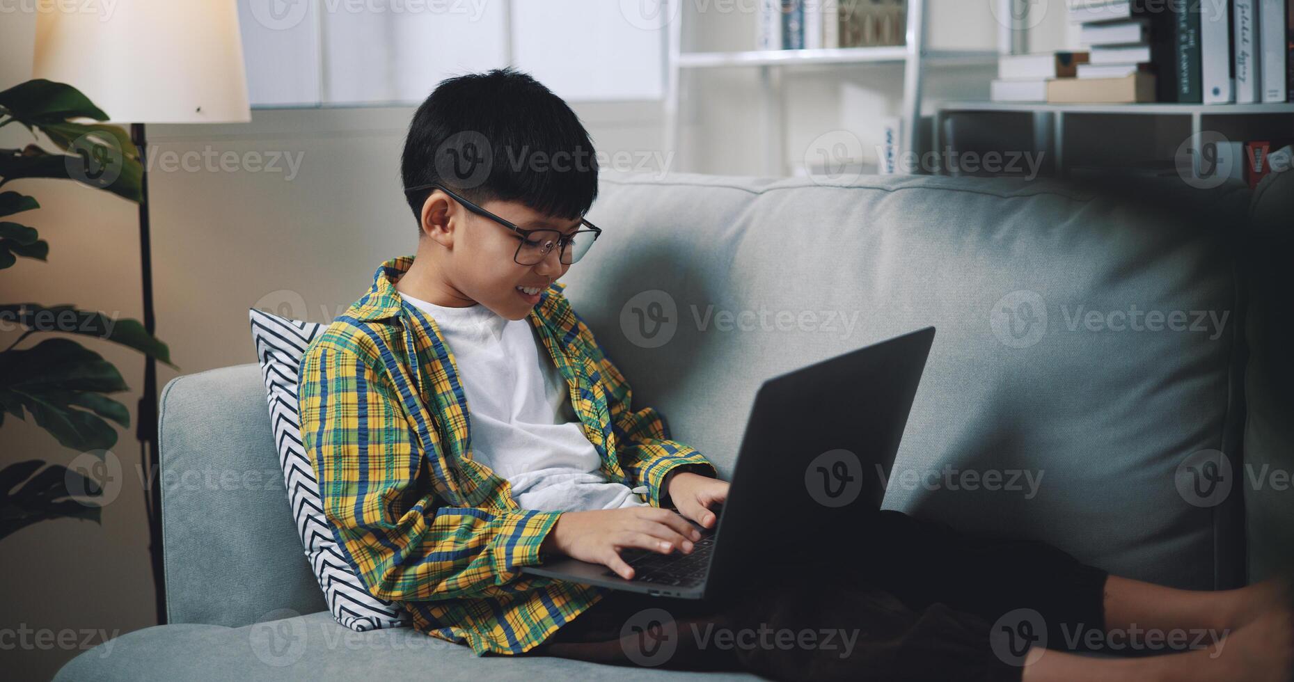 Smart boy use laptop computer to learning online at home photo