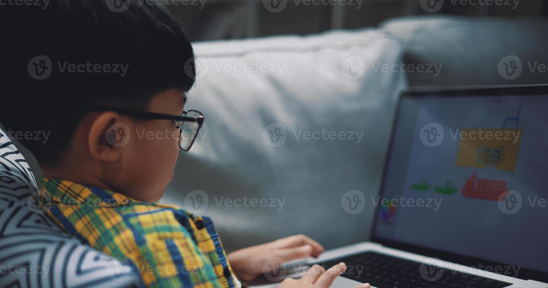 Smart boy use laptop computer to learning online at home photo