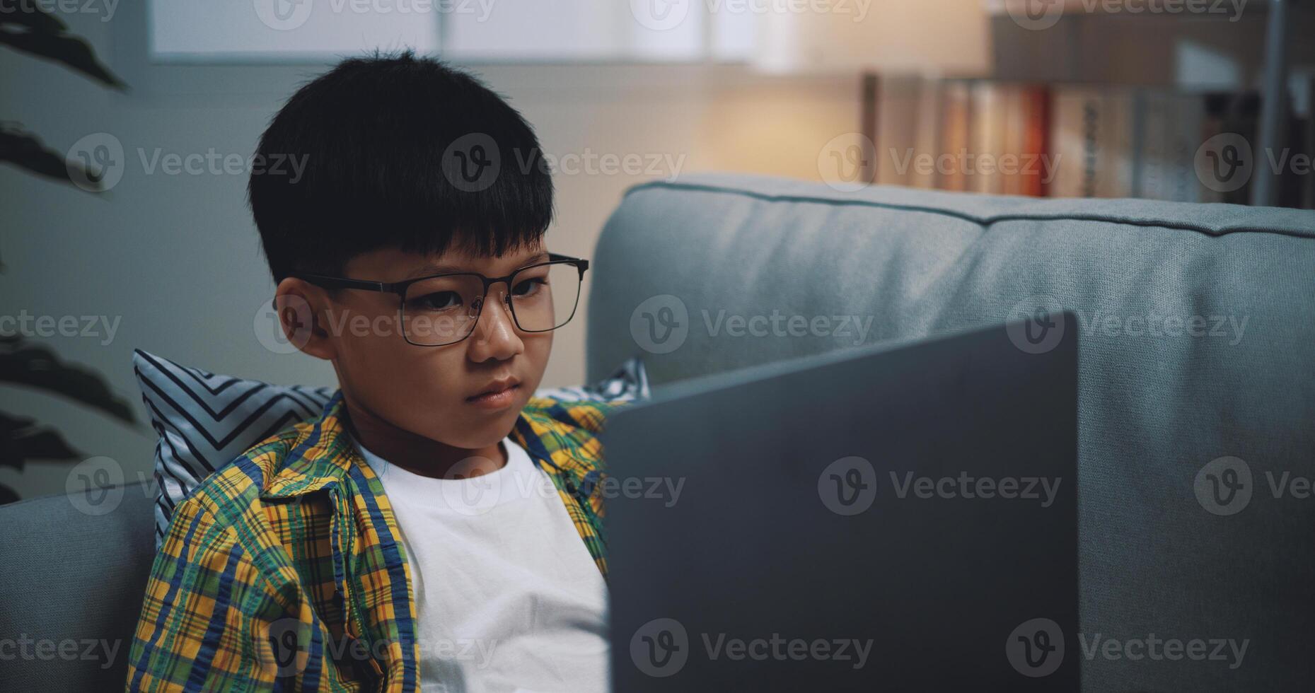 Smart boy use laptop computer to learning online at home photo