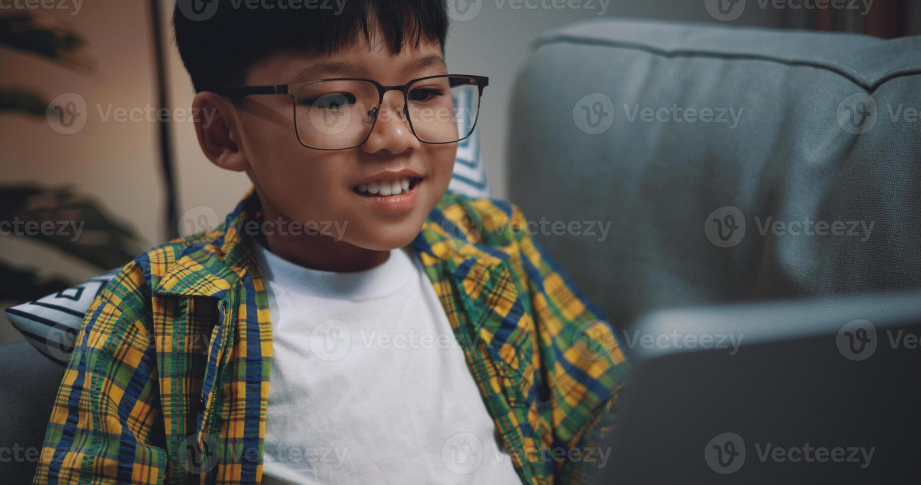 Smart boy use laptop computer to learning online at home photo