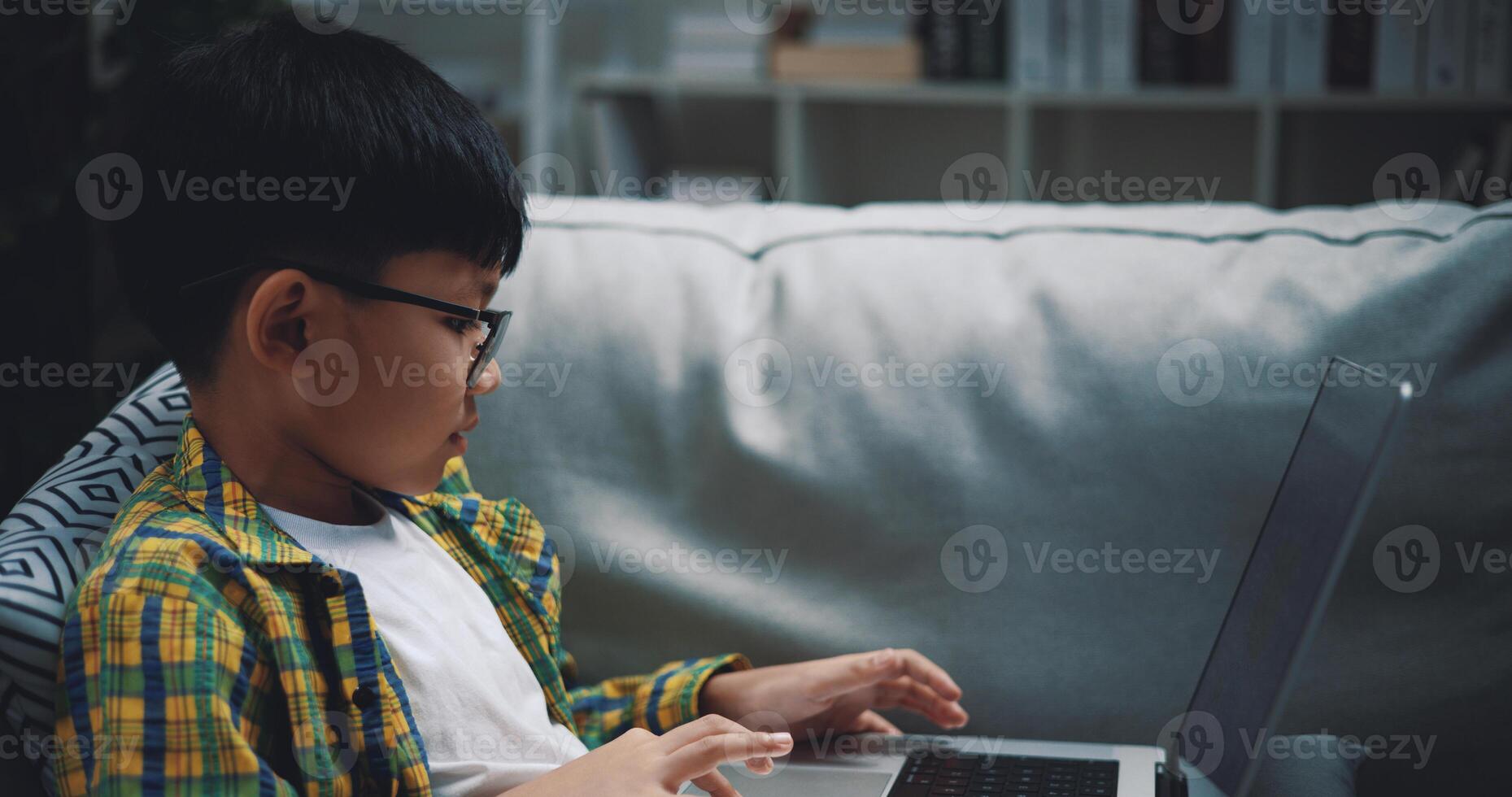 Smart boy use laptop computer to learning online at home photo