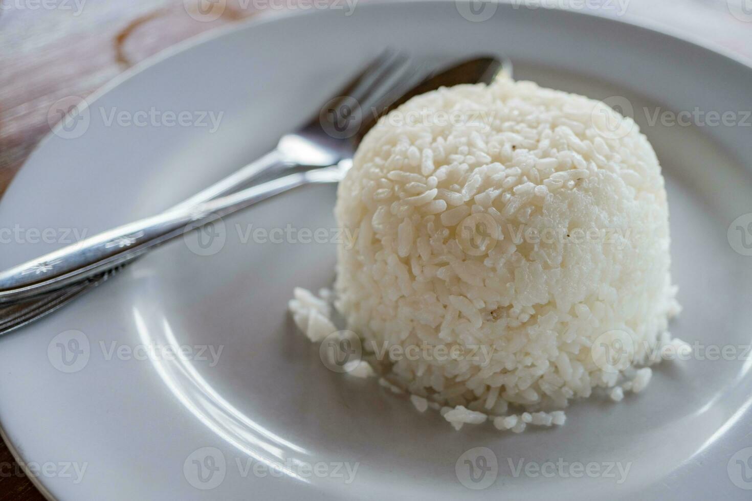 White rice with spoon and fork on white plate. The photo is suitable to use for food background, menu poster and content media.