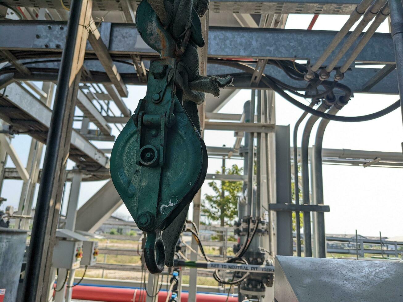 Small pulley on wire robe for lifting material on power plant project. The photo is suitable to use for industrial background and construction content media.