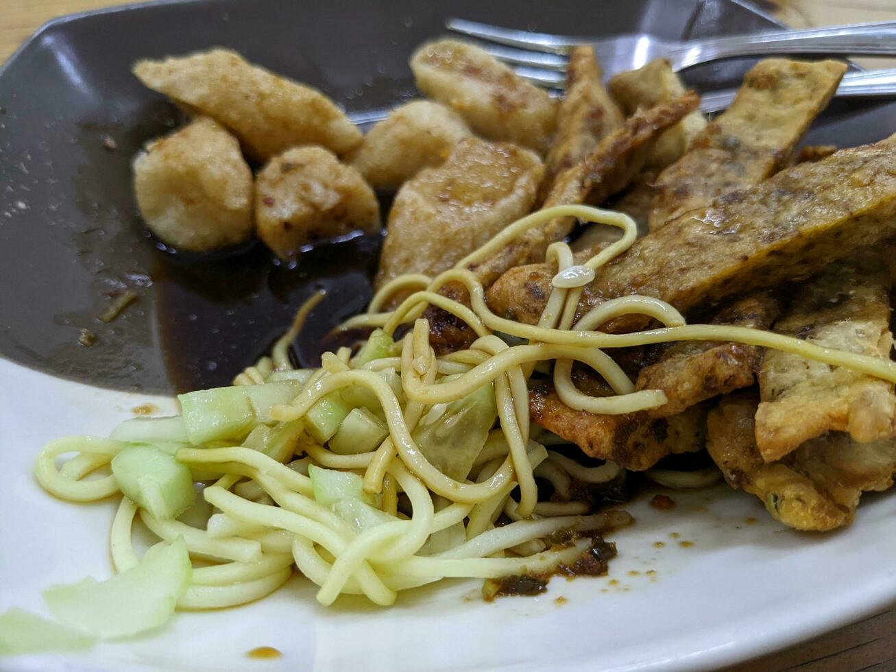 Traditional food from Palembang Sumatra Indonesia, Empek empek with yellow noodles. The photo is suitable to use for traditional food background and food content media.