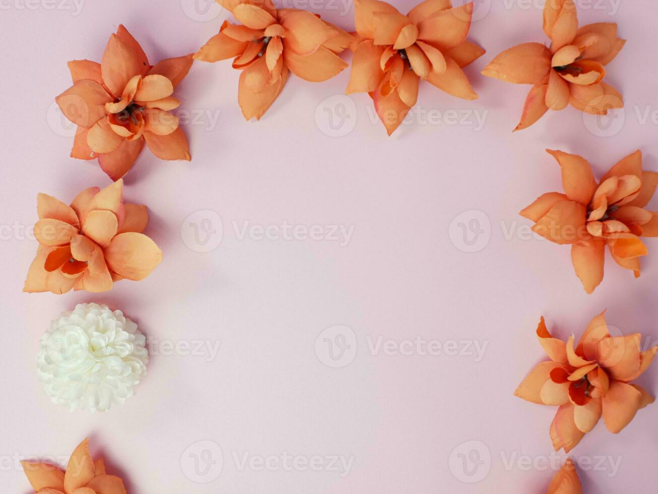 Floral composition. Frame made of orange dry flowers on pastel pink background. Flat lay, top view, copy space photo